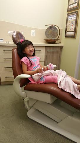 Olivia at the orthodontist's office. Despite her minor correctable needs, she is a happy, thriving young girl.