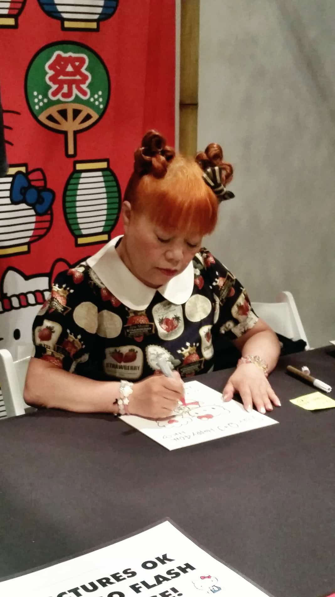 Yuko Yamaguchi, the head designer of Hello Kitty, giving out personalized autographs to fans