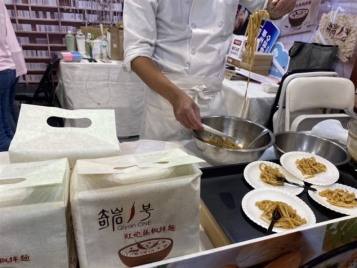 A chef cooks Sichuan peppercorns noodles on-site and distributes samples to the public for tasting