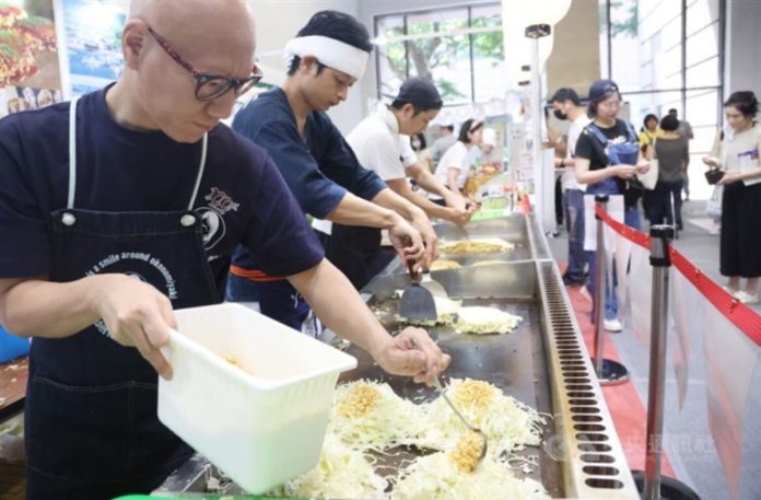 Cooks prepare Hiroshima-styled Japanese savory pancake at the 2023 Taiwan Culinary Exhibition in Taipei