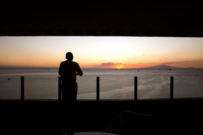 The President watches the sun set over Manila Bay from his hotel balcony in Manila. (Official White House Photo by Pete Souza)